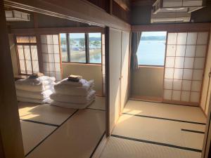 una stanza con asciugamani sul pavimento e finestre di Sado - Hotel - Vacation STAY 82479 a Sado