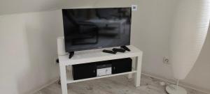 a flat screen tv sitting on a white tv stand at Ferienwohnung in Erfurt Marbach (Maisonette) in Erfurt