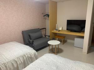 Schlafzimmer mit einem Bett, einem Schreibtisch und einem Stuhl in der Unterkunft Sado - Hotel - Vacation STAY 82476 in Sado