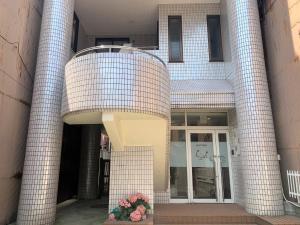 a brick building with a door and flowers in front at Sado - Hotel - Vacation STAY 82476 in Sado