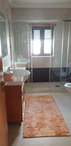 a bathroom with two sinks and a shower and a rug at Vivenda Valverde in Nazaré +24 photos