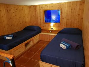two beds in a sauna with a tv in it at Appartamento Limone in Cala Gonone