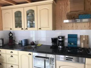 a kitchen with white cabinets and a black counter top at Bêd en Brochje de Hollen in Ryptsjerk