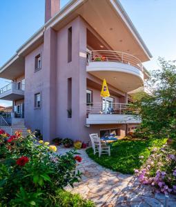 a large pink building with a balcony and flowers at Jasmine in Preveza