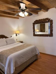 a bedroom with a bed with a ceiling fan and a mirror at Hotel Mi Solar Centro in Uruapan del Progreso