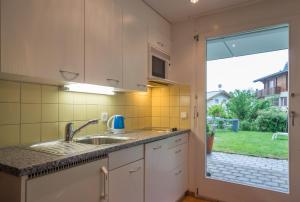 une cuisine avec un évier et une grande fenêtre dans l'établissement Grava - Ferienwohnung für max. 2 Personen, à Laax