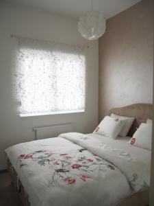 Un dormitorio con una cama con una manta floreada y una ventana. en Apartment Djordje, en Banja Koviljača