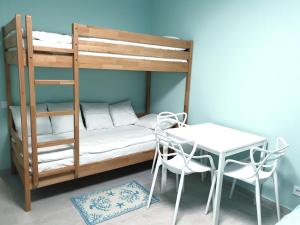 a bedroom with a bunk bed with a table and chairs at Променад "MAXXSEA" in Zatoka