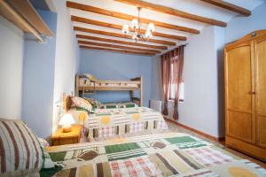 una camera da letto con due letti e soffitto in legno di Casa Amparo - Alquiler íntegro con encanto en Alicante ad Alcoleja Altre 51 foto
