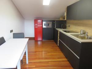 a kitchen with a red refrigerator and a wooden floor at Estancia Edurne in Mungia