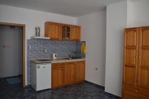 uma cozinha com armários de madeira e um lavatório em Студио Одеса 22 em Sozopol