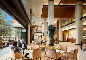 a man and woman sitting at tables in a lobby at Luskin Hotel in Los Angeles