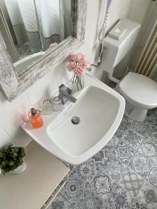 ein Badezimmer mit einem weißen Waschbecken und einem WC in der Unterkunft City Hotel Hunsrücker Hof in Boppard