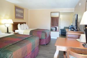 Habitación de hotel con 2 camas y escritorio en Travelodge by Wyndham Trinidad, en Trinidad