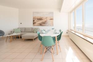 a living room with a table and chairs and a couch at SeaDreams in Middelkerke