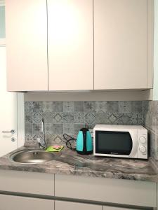 a kitchen counter with a microwave and a sink at Променад "MAXXSEA" in Zatoka