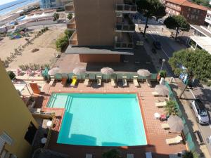 - une vue sur la piscine bordée de chaises et de parasols dans l'établissement Hotel Reno, à Lido di Savio