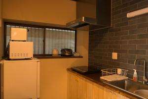 a kitchen with a white refrigerator and a sink at SyukuyaYokohama Main Building 1F - Vacation STAY 82573 in Kitagatamachi