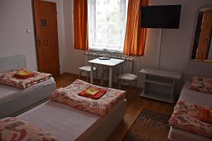 sala de estar con 2 camas, mesa y ventana en Villa Malva, en Łomianki