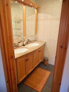 ein Badezimmer mit 2 Waschbecken und einem Spiegel in der Unterkunft Mira Piz Signina - Ferienwohnung für max. 4 Personen in Laax