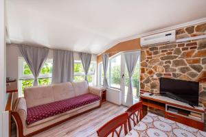 a living room with a couch and a tv at Olive House Zadar in Zadar