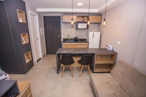 een keuken met een tafel en stoelen in een kamer bij Studio Andar Alto e Face Norte - ALL1611 in Curitiba