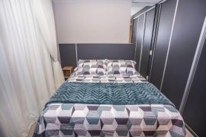 een slaapkamer met een bed met een geruite deken bij Studio Andar Alto e Face Norte - ALL1611 in Curitiba