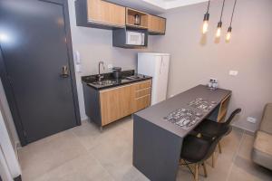 een keuken met een aanrecht, een tafel en een koelkast bij Studio Andar Alto e Face Norte - ALL1611 in Curitiba +125 foto's