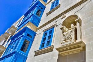 a building with blue windows and a statue at The Exiles Hotel in Sliema