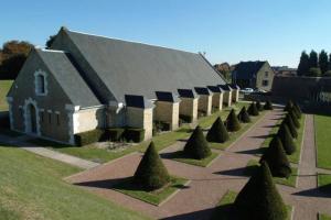 a large building with a row of trees in front of it at Au coeur des remparts, residence du château* in Gravelines