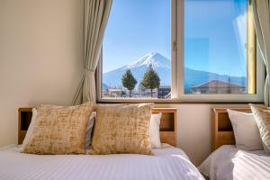 1 dormitorio con vistas a la montaña desde una ventana en Minamitsuru-gun - House - Vacation STAY 82504, en Fujikawaguchiko