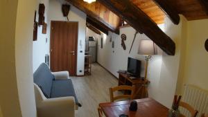 a living room with a couch and a tv and a table at appartamenti la ginestra in Cesana Torinese