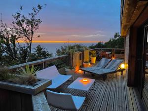 eine Terrasse mit einem Tisch und Stühlen sowie Meerblick in der Unterkunft Le Bout du Monde in Saint-Léonard