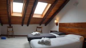 a bedroom with two beds and two windows at appartamenti la ginestra in Cesana Torinese