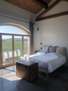 a bedroom with a large bed and a balcony at Tenuta Le More in Calosso