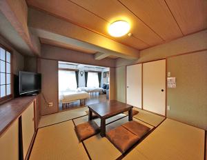 een kleine woonkamer met een tafel en een televisie bij La Foret Fujimi - Vacation STAY 83089 in Hiroshima