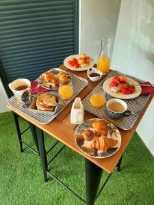 a table with plates of food and orange juice at La Villa Claudia Jardin et Spa in Pennautier +24 photos