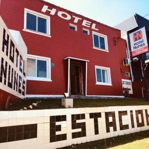 un edificio rojo con un cartel de hotel delante en Hotel Nunes, en Curitiba
