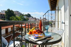 a bowl of fruit on a glass table on a balcony at Orianna Suites skiathos in Skiathos Town