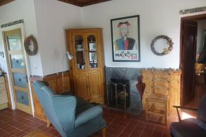 een woonkamer met een stoel en een open haard bij Bell Cottage in Gortahork