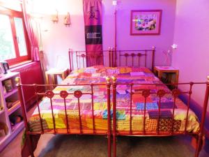 a bedroom with a bed with a colorful comforter at Forgatz' Studio in Bruges