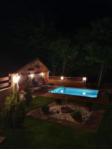 un patio trasero con piscina por la noche en Lodge Zeleni svet, en Crni Vrh