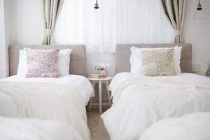 2 łóżka z białymi kocami i poduszkami w pokoju w obiekcie Bijou Suites Sorriso - Vacation STAY 82795 w Osace