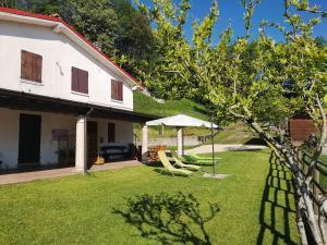 a yard with two lawn chairs and an umbrella at Baita la Gioiosa in Livemmo