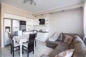 a living room with a couch and a table and a kitchen at Apartament Masuria in Ełk