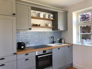 a kitchen with white cabinets and a sink at Katjas Kate Gartenwohnung in Prerow