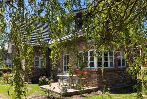 a brick house with a table in front of it at Katjas Kate Gartenwohnung in Prerow