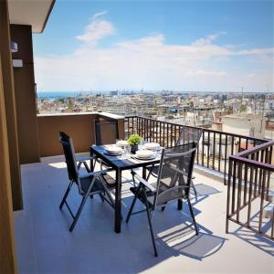 een tafel en stoelen op een balkon met uitzicht bij Seaview Deluxe Apartments Thessaloniki in Thessaloniki