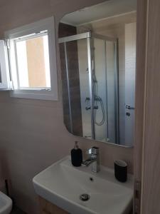 a bathroom with a sink and a mirror at Seaview Deluxe Apartments Thessaloniki in Thessaloniki