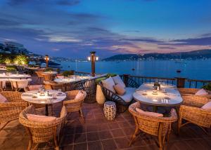 a dining area with tables, chairs and umbrellas at Bebek Hotel By The Stay Collection -Adults Only in Istanbul